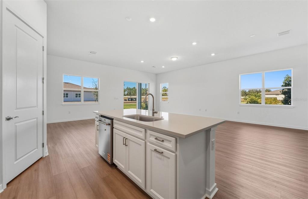 13655 Cyn Rdg Road Spring Hill, FL 34610 - Photo 4 of 28 a kitchen with stainless steel appliances granite countertop a stove a sink and a refrigerator with wooden floor