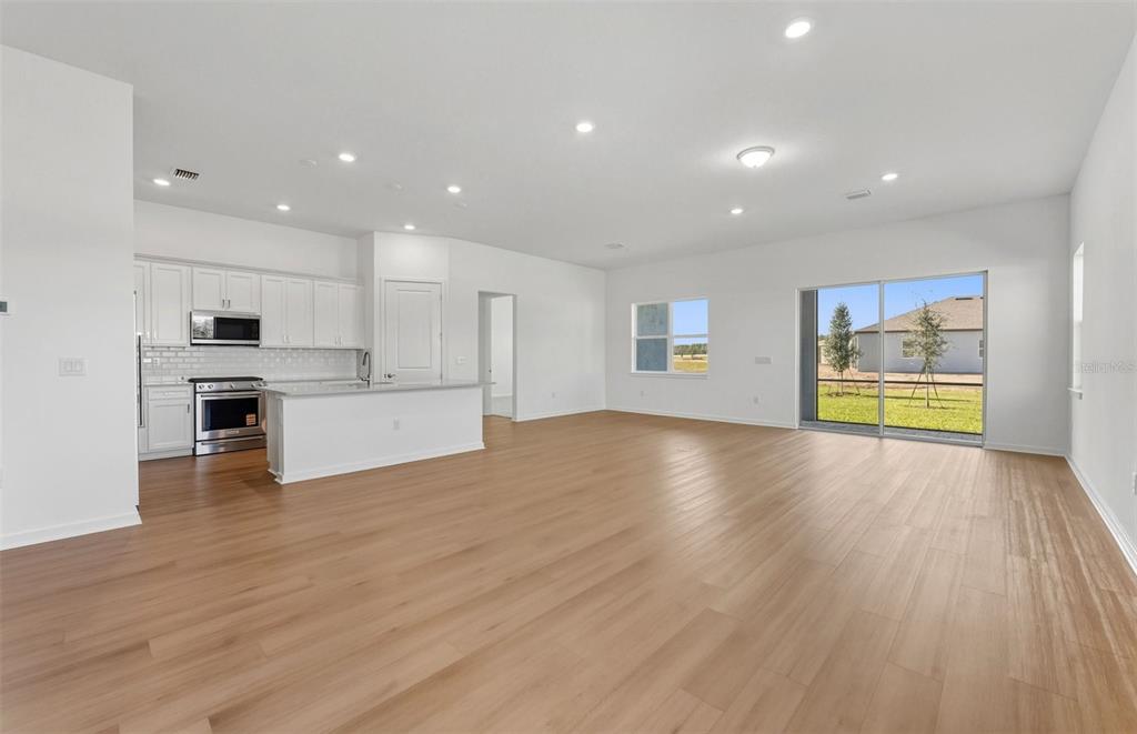 13655 Cyn Rdg Road Spring Hill, FL 34610 - Photo 7 of 28 a view of an empty room with a window and wooden floor
