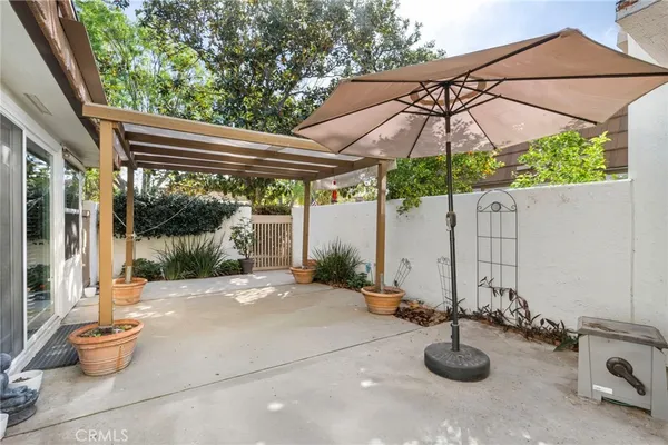 a kitchen with stainless steel appliances granite countertop a refrigerator a stove a sink a dining table and chairs with wooden floor