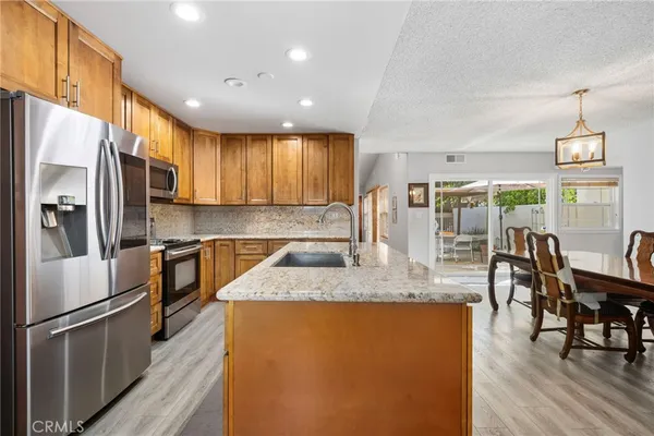 a kitchen with stainless steel appliances granite countertop a stove a sink and a refrigerator