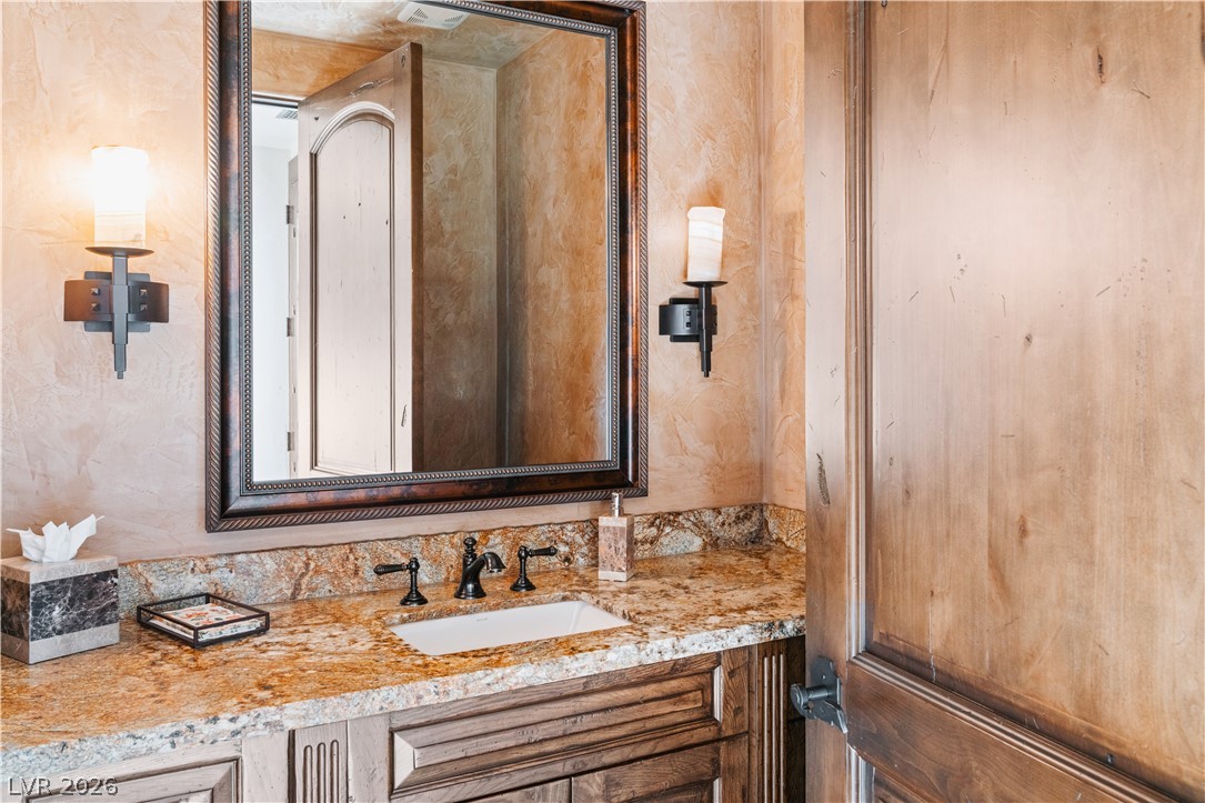 1123 Christian Road Henderson, NV 89002 - Photo 41 of 94 Ornate fixtures and granite counters adorn this elegant bathroom vanity, creating a refined aesthetic.