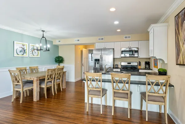 a view of a dining room with furniture wooden floor and a kitchen