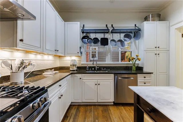 a kitchen with stainless steel appliances a table chairs and a refrigerator