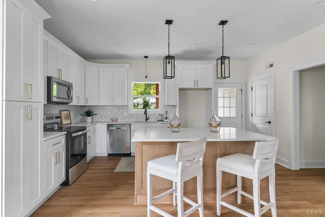 a kitchen with appliances cabinets and chair