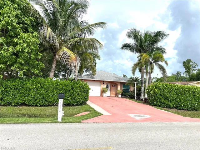 a front view of a house with yard and green space