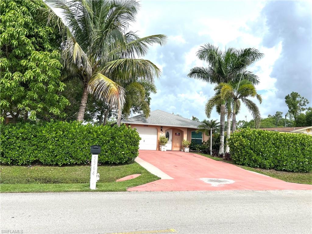 a front view of a house with yard and green space