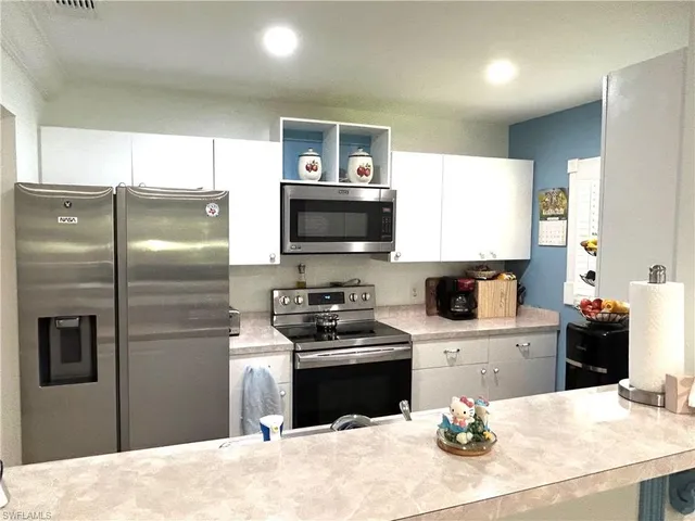 a kitchen with a refrigerator and a stove top oven