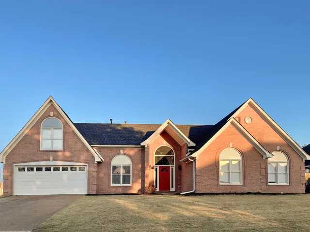 a view of a house with a yard and garage