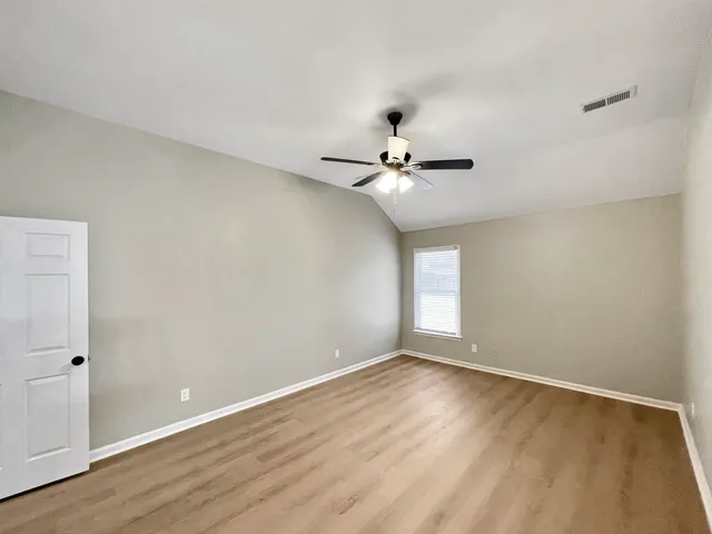 a view of empty room with fireplace and fan