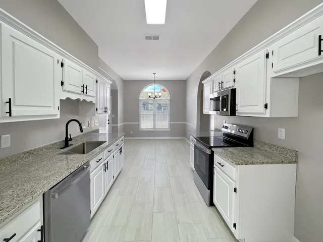 a kitchen with stainless steel appliances granite countertop a stove a sink and a refrigerator