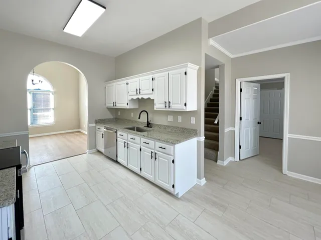 an empty room with windows and fireplace