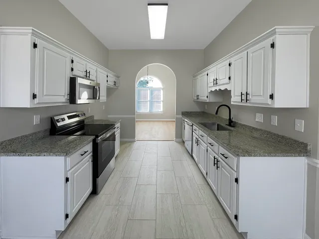 a large kitchen with lot of cabinets and glass door