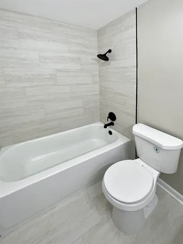 a white toilet and tub sitting next to a bathroom sink