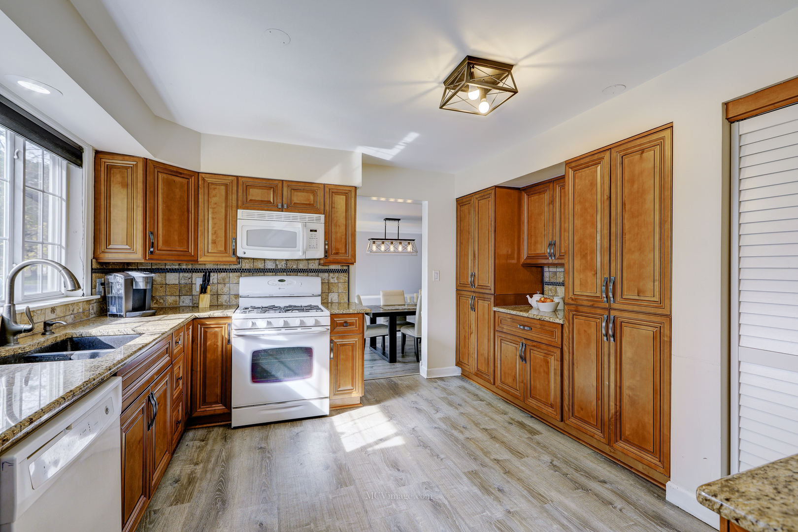 3 Manor Road Lake Zurich, IL 60047 - Photo 6 of 35 a kitchen with stainless steel appliances granite countertop a stove top oven a sink dishwasher a refrigerator and cabinets with wooden floor