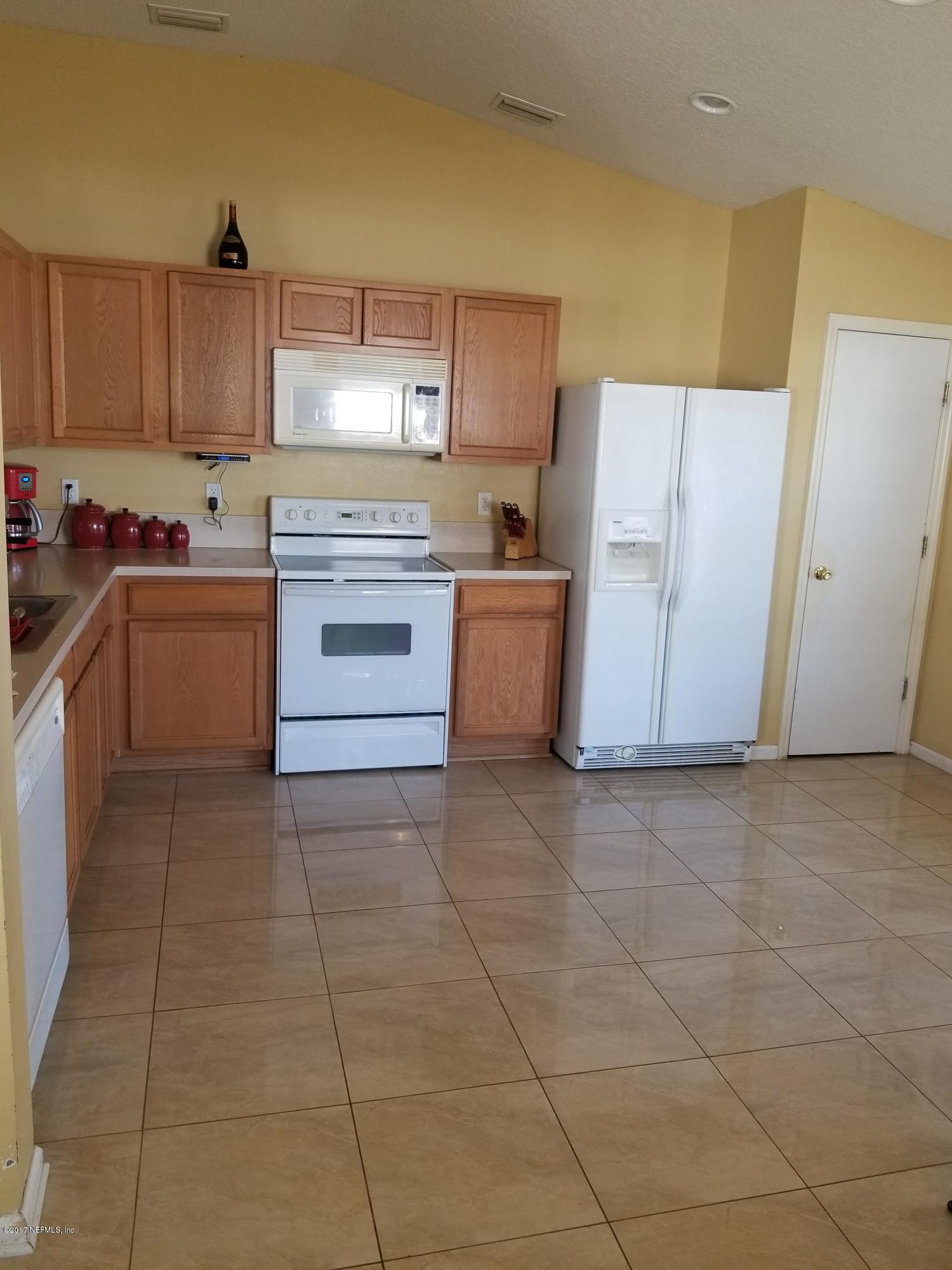 931 Morning Light Road Jacksonville, FL 32218 - Photo 18 of 33 a kitchen with a stove a sink and a refrigerator
