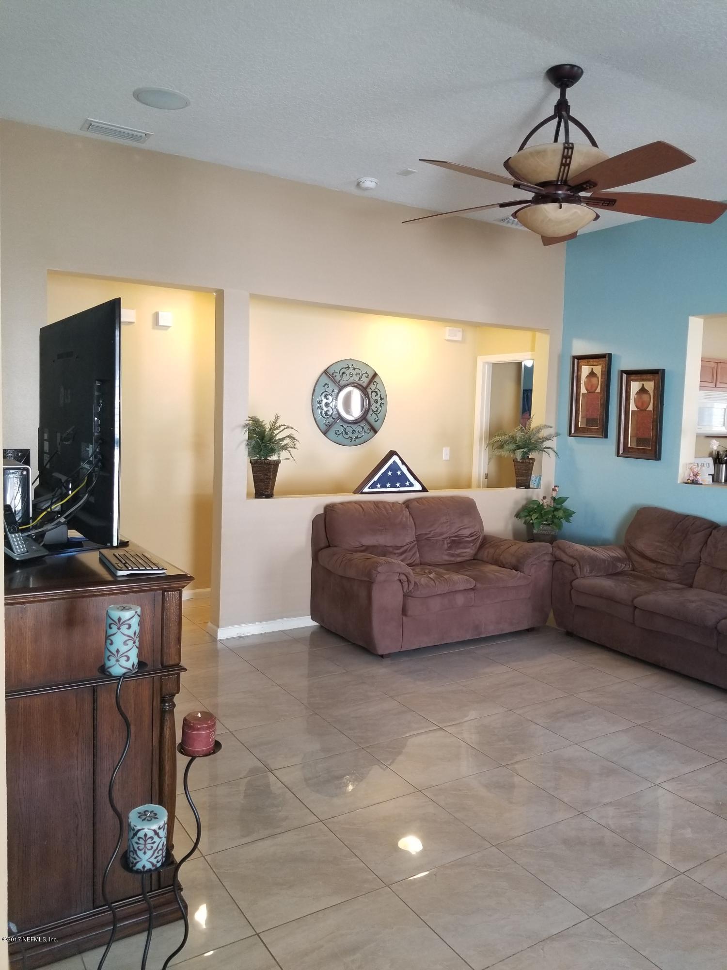 931 Morning Light Road Jacksonville, FL 32218 - Photo 8 of 33 a living room with a couch and a flat screen tv