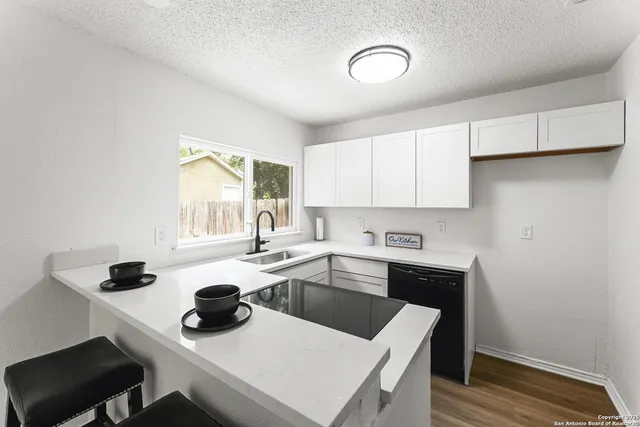 a kitchen with a sink a stove and cabinets
