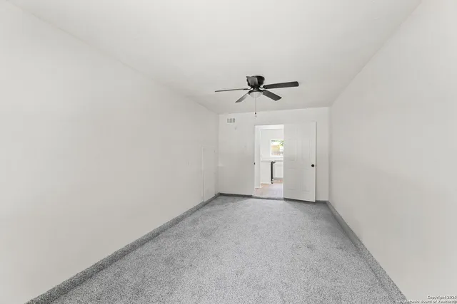 a view of an empty room and a ceiling fan