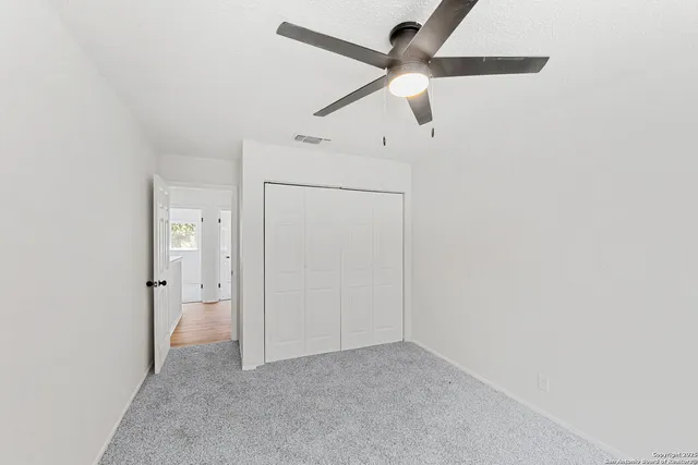 an empty room with fan and a ceiling fan