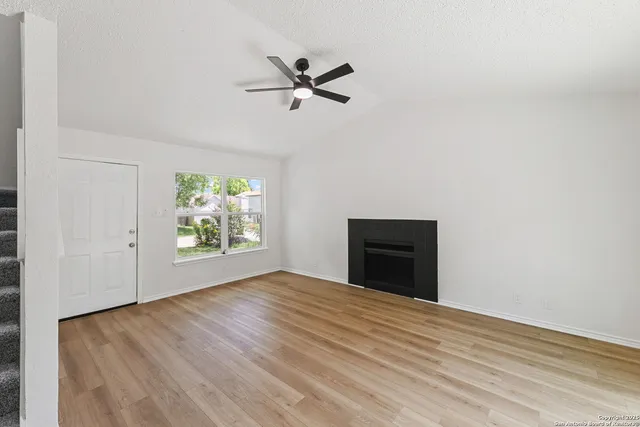 a view of empty room with wooden floor