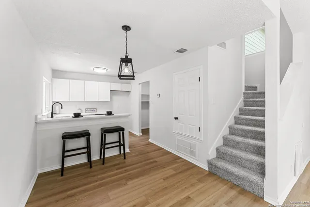 a view of a hallway with wooden floor and staircase
