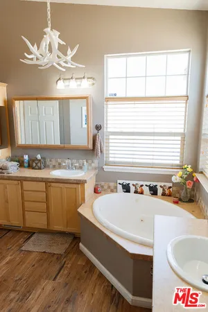 a bathroom with a granite countertop sink and a bathtub