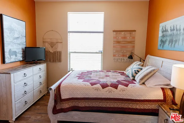 a bedroom with a bed and a flat screen tv