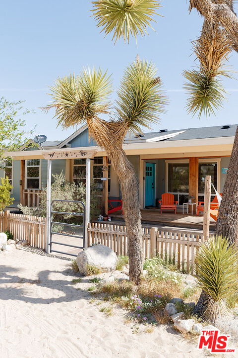 55626 Pipes Canyon Road Yucca Valley, CA 92284 - Photo 19 of 61 a view of a house with a small yard and plants