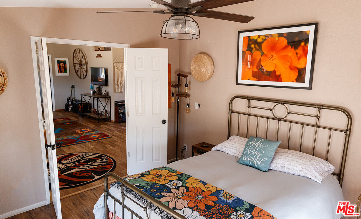 55626 Pipes Canyon Road Yucca Valley, CA 92284 - Photo 46 of 61 a bedroom with a bed and wooden floor