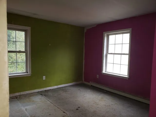 an empty room with windows and closet