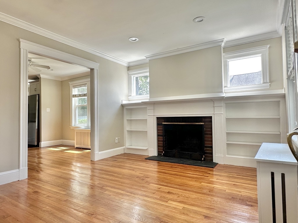8 A Mellon Road Wellesley, MA 02482 - Photo 6 of 22 a view of a livingroom with wooden floor and a fireplace