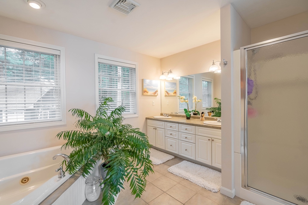 33 Mountain Brook Road Sturbridge, MA 01566 - Photo 22 of 41 a bathroom with a granite countertop sink a large mirror a bathtub and next to a window