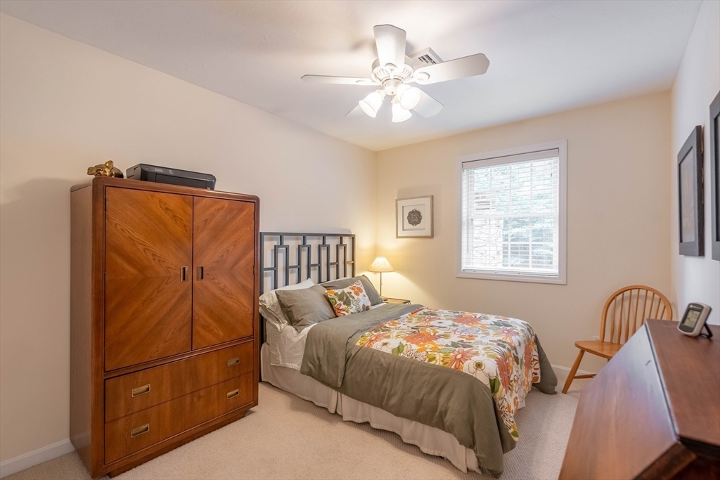33 Mountain Brook Road Sturbridge, MA 01566 - Photo 26 of 41 a bedroom with a bed and a chandelier