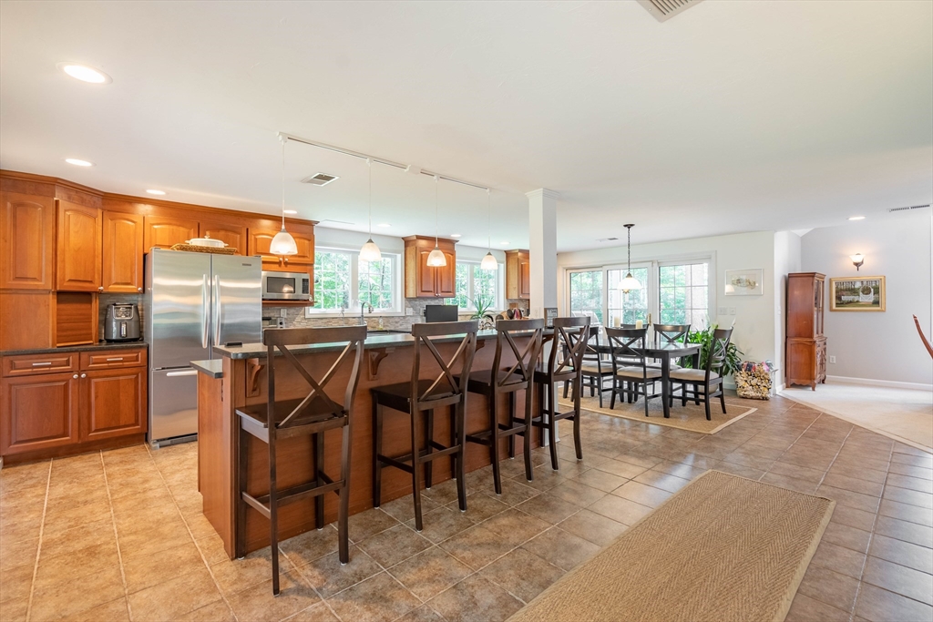 33 Mountain Brook Road Sturbridge, MA 01566 - Photo 7 of 41 a group of people sitting at kitchen counter space and stainless steel appliances