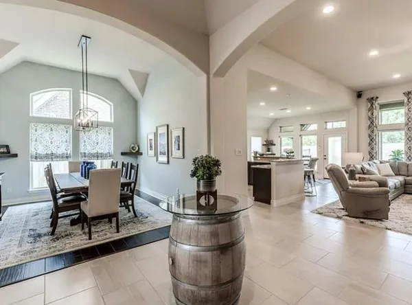 a living room with furniture a chandelier and a dining table