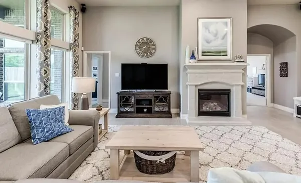 a living room with furniture a fireplace and a flat screen tv
