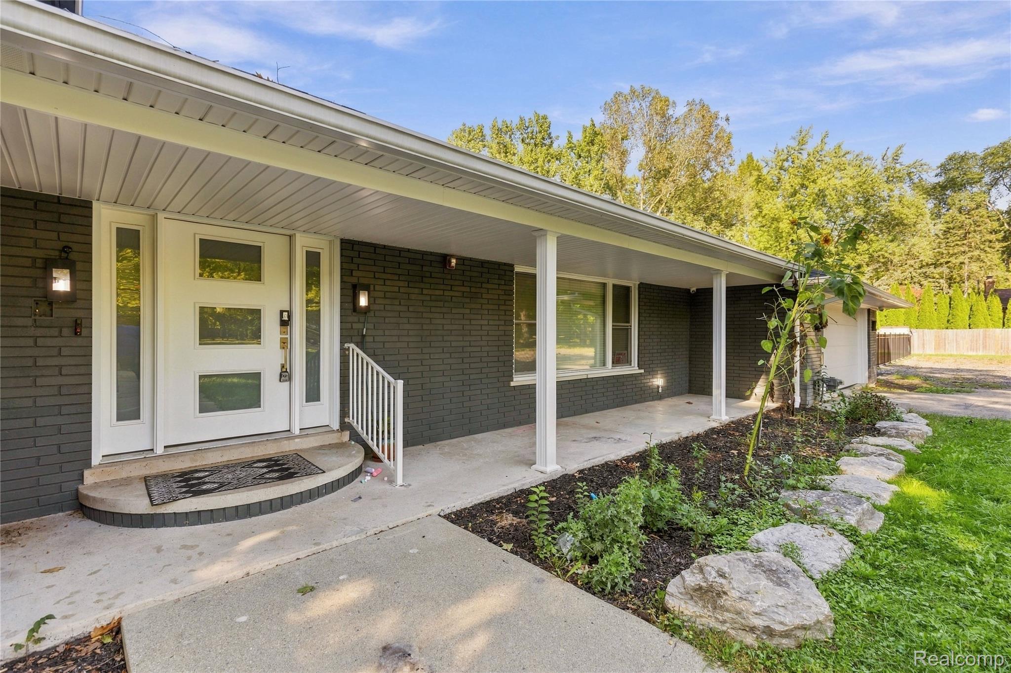 15879 Millar Road Clinton Township, MI 48036 - Photo 42 of 65 Brick facade with a covered porch featuring white support columns