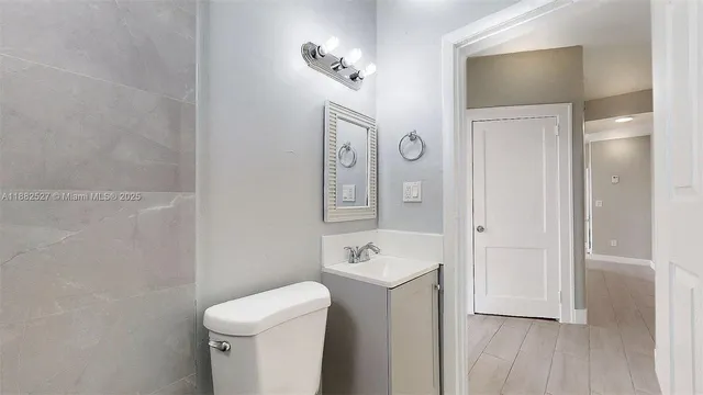 a bathroom with a toilet a sink and mirror