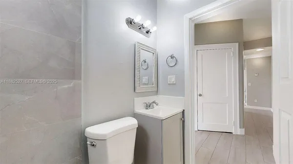 a bathroom with a toilet a sink and a mirror