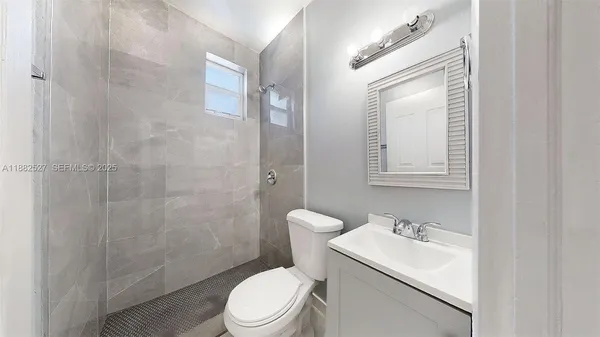 a bathroom with a toilet sink vanity and shower
