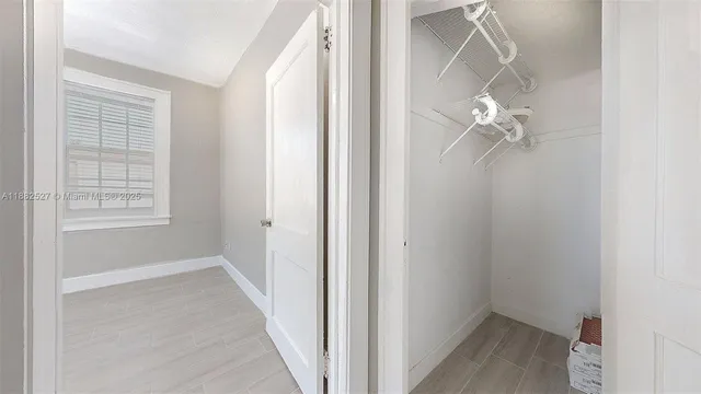 a view of a room with a window and wooden floor