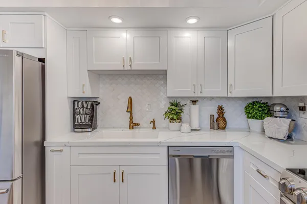 a kitchen with stainless steel appliances white cabinets and a refrigerator