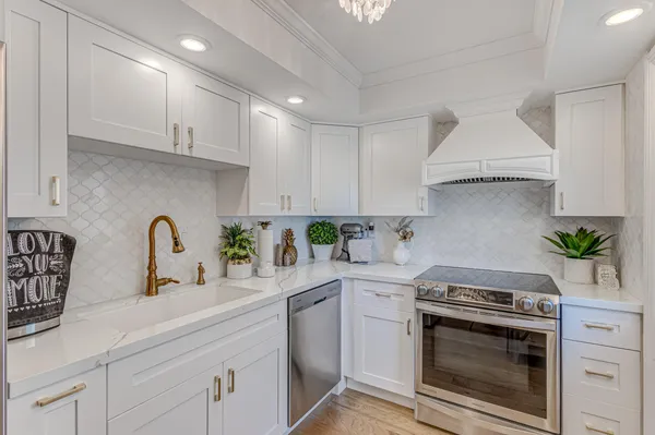 a kitchen with stainless steel appliances granite countertop a sink a stove and cabinets
