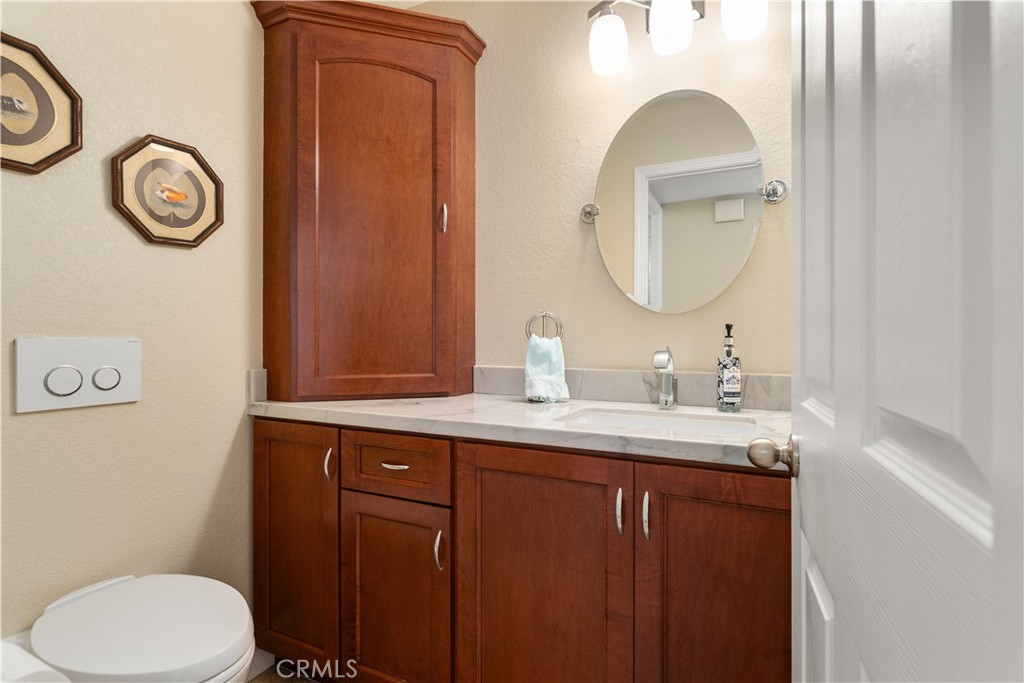 1106 Ridgecrest Circle Costa Mesa, CA 92627 - Photo 5 of 31 a bathroom with a toilet sink vanity and mirror