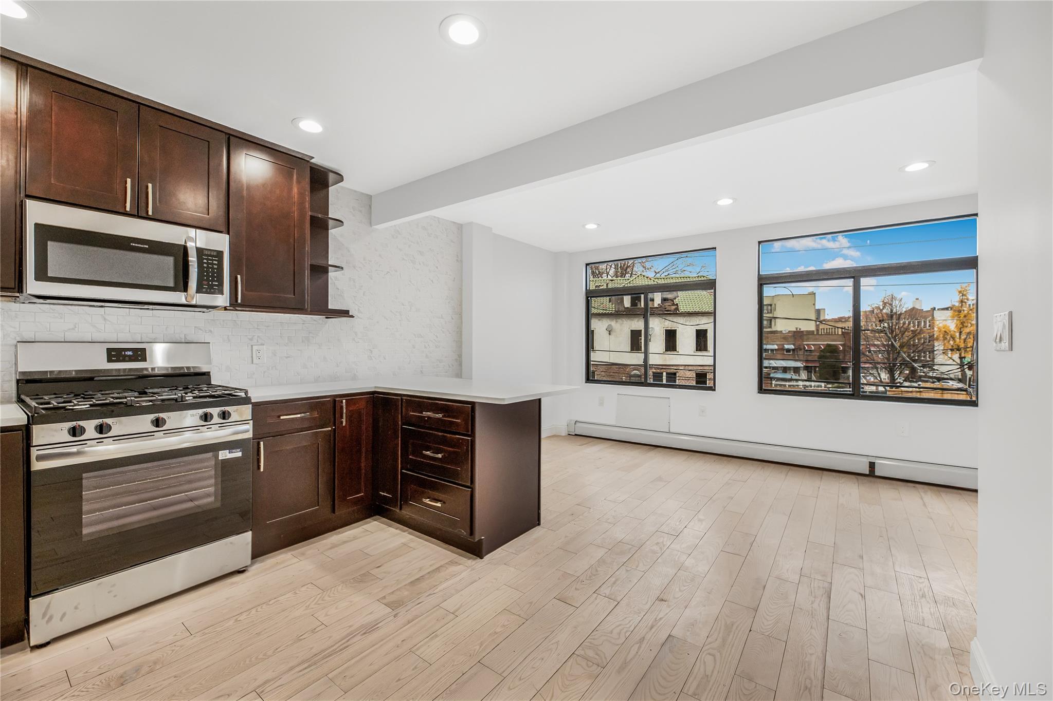 3067 Williamsbridge Road Bronx, NY 10467 - Photo 5 of 29 a kitchen with stainless steel appliances granite countertop a stove and a wooden cabinets