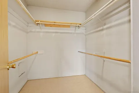 a view of a bedroom with wooden floor and window