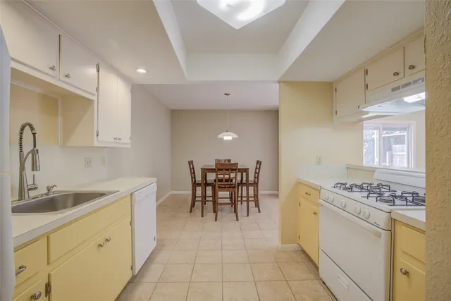 a kitchen with a table chairs sink and cabinets