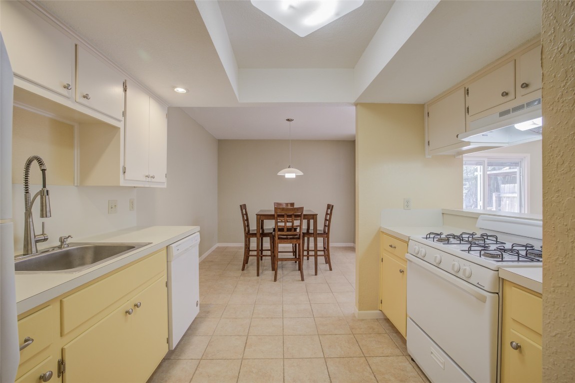 306 Corral Lane, Unit B Austin, TX 78745 - Photo 15 of 33 a kitchen with a table chairs sink and cabinets