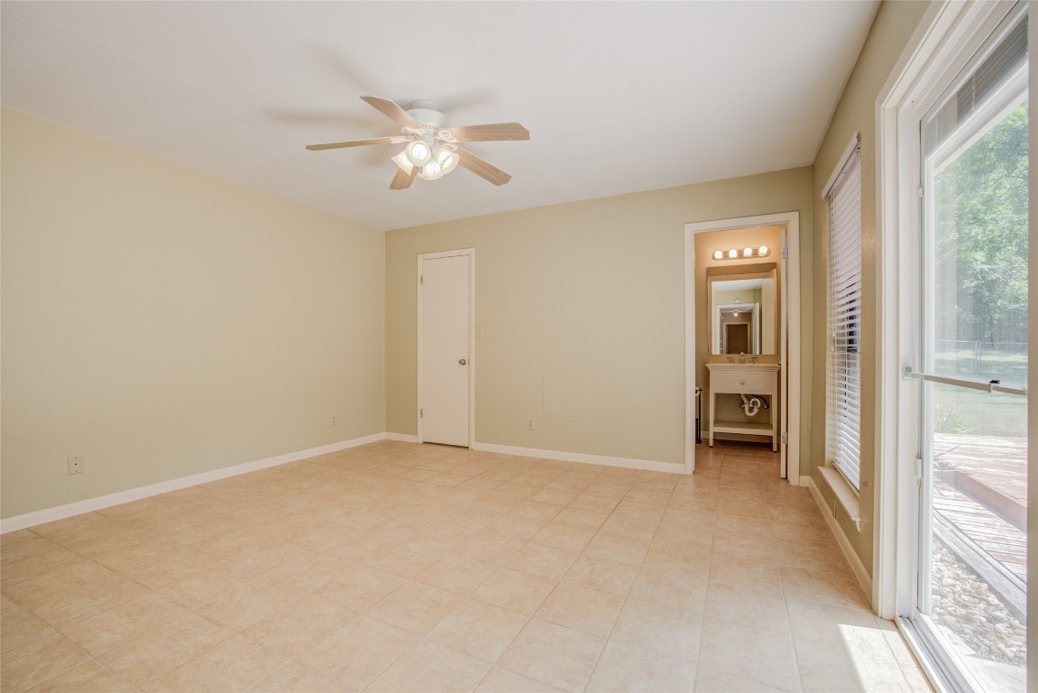 306 Corral Lane, Unit B Austin, TX 78745 - Photo 17 of 33 an empty room with windows and fan