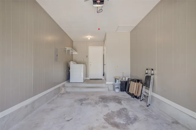 a view of a hallway with a chair and frames on th wall